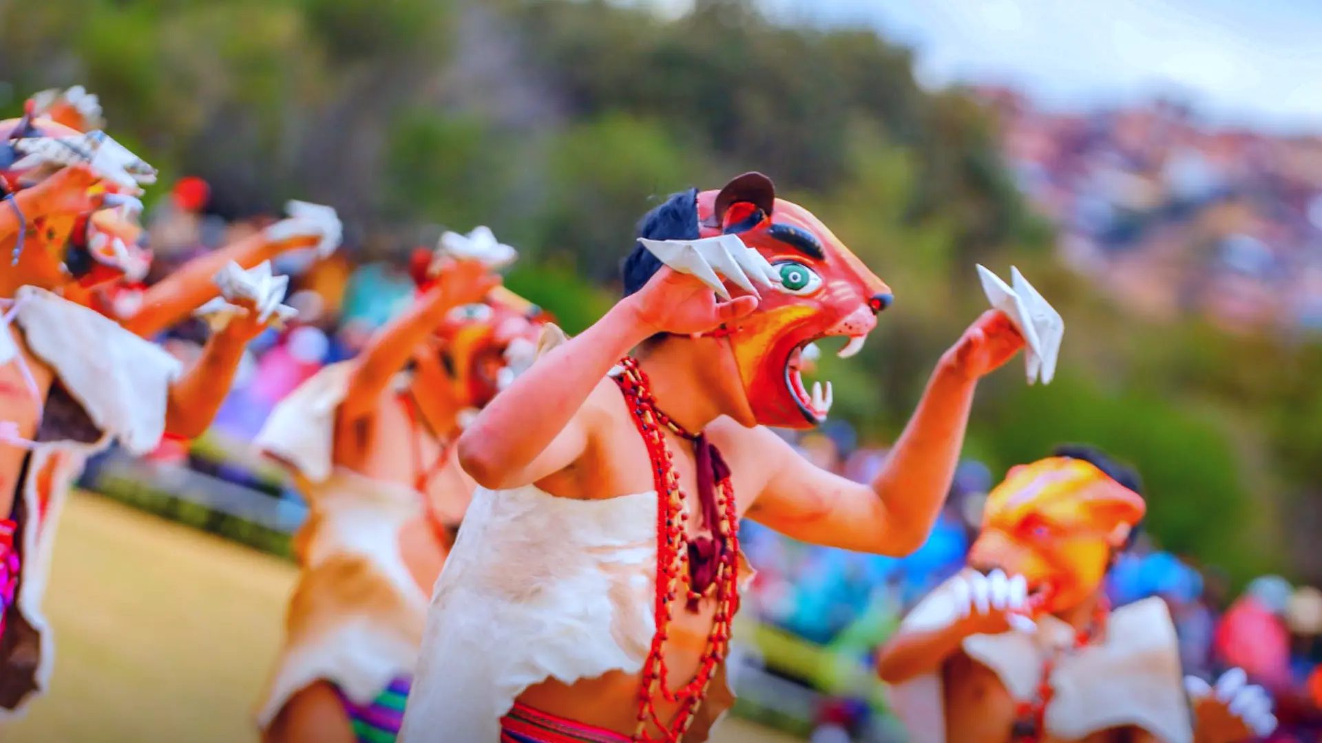 A dancer wearing a puma mask and a traditional costume, performing an energetic dance during the Warachikuy Inca Ritual. - Magical Cusco Travel Agency