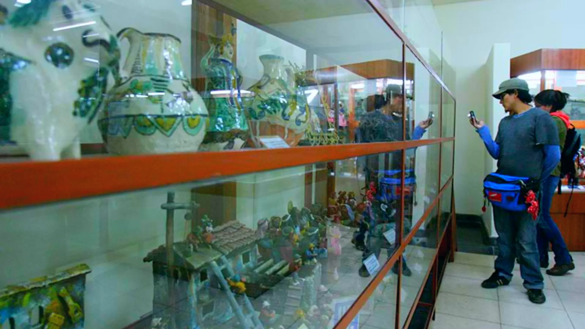 Glass cases displaying Andean ceramics, figurines, and cultural dioramas inside the Cusco Museum of Popular Art – Magical Cusco Travel Agency
